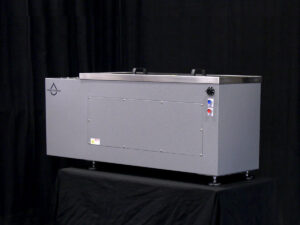 white box sitting on top of a black table, representing the Pro Benchtop EXT Ultrasonic Cleaner in an industrial setting